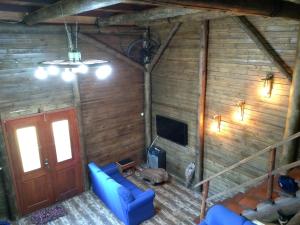 an attic room with a blue couch and a tv at CHALÉ ESTÂNCIA OURO VERDE in Lages