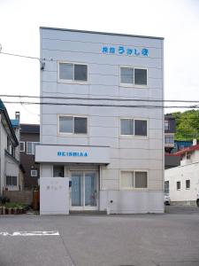 un edificio bianco con un cartello sopra di Shimanoyado Rebunshiri a Rebun