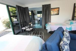 a hotel room with two beds and a couch at Greenmeadows on Gloucester in Napier