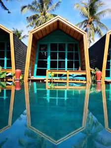 een zwembad tegenover een resort met palmbomen bij Absolute Villa in Gili Trawangan