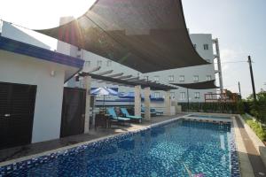 a swimming pool with chairs and umbrellas next to a building at Blue Lotus Hotel in Davao City