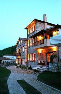 a large stone building with lights on it at Archontiko Athina in Koumariá