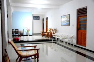 ein Wartezimmer mit Stühlen, einem Tisch und einer Tür in der Unterkunft Royal Views Residence in Anuradhapura