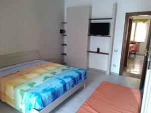 sypialnia z łóżkiem z kolorowym kocem w obiekcie B&B I Gigli w mieście Brusciano