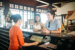 a man and woman standing at a cash register at Lapochine Beach Resort (formerly Ana Mandara Hue) in Hue