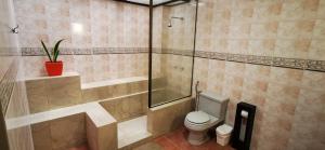 y baño con aseo y ducha acristalada. en Apartamento mediano ideal para parejas o ejecutivos, en Manta