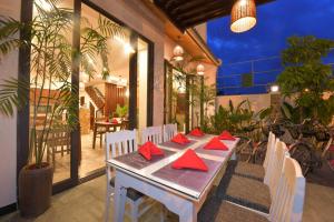 una mesa de comedor con servilletas rojas en el patio en Saclo Villa and Hostel, en Hoi An