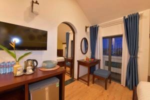 a living room with a tv and a couch at Saclo Villa and Hostel in Hoi An