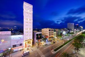 a city street at night with a tall building at Mercury Boutique Hotel & Apartment Da Nang in Da Nang