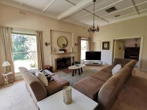 uma sala de estar com um sofá e uma televisão em Lake House Benalla em Benalla