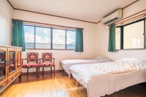 1 dormitorio con 2 camas y 2 sillas en 徐宅 en Nara