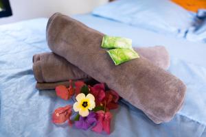 - une pile de serviettes et de fleurs sur le lit dans l'établissement Vanilla Cottage Tetebatu, à Tetebatu