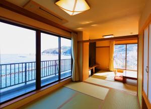 Una habitación con balcón con vista al mar. en 熱海温泉 湯の宿 平鶴, en Atami
