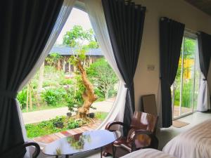 a bedroom with a window with a view of a tree at Binh Minh Eco Lodge in Can Tho