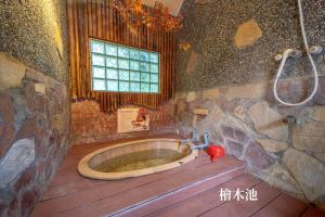 baño con bañera de madera y ventana en 一口井溫泉 One Well Hot Spring en Jiaoxi