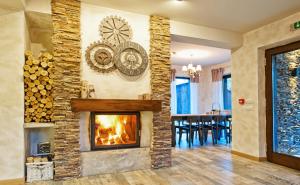a living room with a fireplace and a dining room at Chalet Hovel in Mănăstirea Humorului