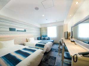 Säng eller sängar i ett rum på Hotel Torifito Naha Asahibashi