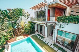 a house with a swimming pool and a balcony at Nazeki Villa in Uluwatu