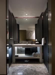 a bathroom with a sink and a mirror at Paco Hotel Gangding Metro Guangzhou-Free Shuttle Bus fir Canton Fair in Guangzhou