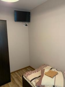 a room with a bed with a tv on the wall at Zajazd Skorpion Rzeniszów in Koziegłowy +4 photos