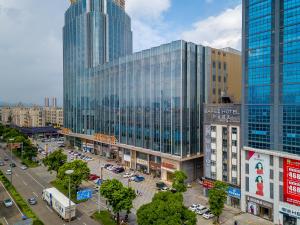 a city with tall buildings and a parking lot with cars at Zhongshan Bafei Hotel in Zhongshan