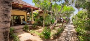 a house with a pathway leading to the front yard at Bali Bhuana Beach Cottages in Amed