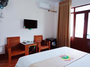 a bedroom with a bed and a desk and a tv at Anh Minh Hotel in Tam Ðảo