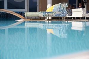a couch sitting next to a swimming pool at Scalaria Sunset Wing in St. Wolfgang