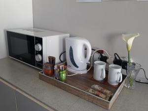 a kitchen counter with a microwave and a tray at Field's Rest in Port Elizabeth