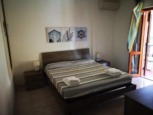 a bedroom with a bed with two towels on it at Villa Malu in Anzio