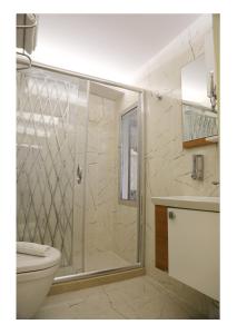 y baño con ducha, aseo y lavamanos. en Fimka Hotel, en Estambul