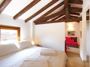 1 dormitorio con 1 cama blanca y 1 silla roja en Mercalli II, en Milán