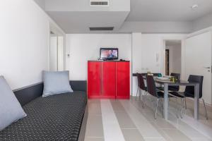 a living room with a red cabinet and a table at Residence Altomare in Riccione