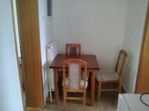 a dining room table with two chairs and a wooden table at Sobe Nevenka in Vrnjačka Banja