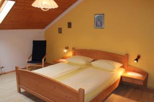 ein Schlafzimmer mit einem Holzbett und einem Stuhl in der Unterkunft Familienferienhof Kroner in Zwiesel