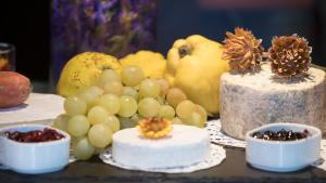 a table topped with cakes and grapes and fruit at Nala Individuellhotel in Innsbruck