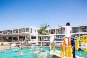 un gruppo di persone che saltano in piscina in un resort di Atali Grand Resort a Balíon