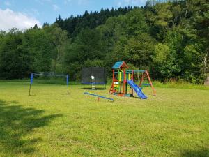 dos equipos de juegos para niños en un campo de césped en Domki u Brzeginy, en Ustrzyki Dolne