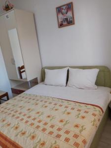 a bed with a blanket on top of it at House Nativa in Ohrid