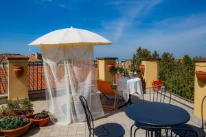 a patio with a table and a white umbrella at B&B Buonfiglio Cicconcelli - Terrazza panoramica in Frascati