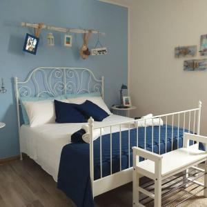 una camera con un letto bianco e una parete blu di B&B Marsà a Marzamemi