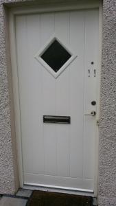 a white garage door with a window on it at Lerwick Garden Cottage in Inverness
