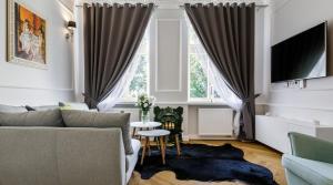 ein Wohnzimmer mit einem Sofa und einem Tisch in der Unterkunft MY KRAKOW Apartments - Topolowa 8 in Krakau