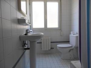 a bathroom with a toilet, sink, and tub at Hostal ** EC León in León