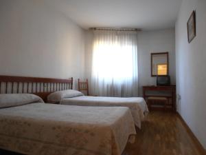 a bedroom with a bed and a dresser at Hostal ** EC León in León