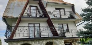 un edificio de apartamentos con balcones y graffiti en él en Pokoje Gościnne Anna en Poronin
