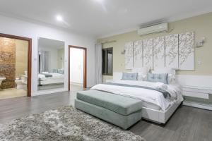 a bedroom with a large white bed and a rug at Fallsway Villas in Lusaka +12 photos