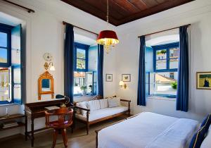 a bedroom with a bed and a couch and windows at Orloff Boutique Hotel in Hydra