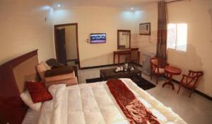 a bedroom with a large bed and a living room at Fakher Yanbu Hotel in Yanbu