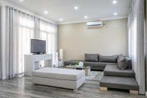 a living room with a couch and a tv at Fallsway Villas in Lusaka